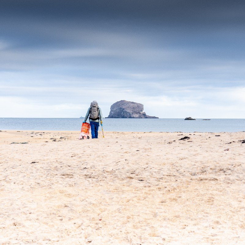 anti black friday beach clean with ocean vertical the bass rock east lothian