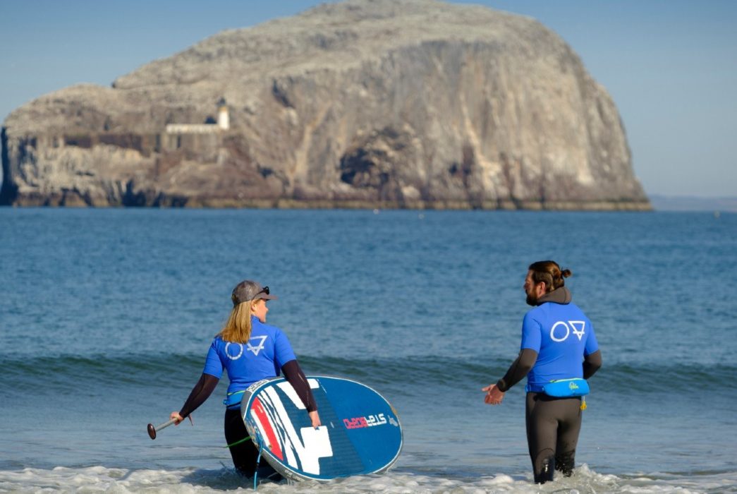 Mollie Hughes is SUP paddle boarding with Starboard and the Bass Rock in the background East Lothian Scotland